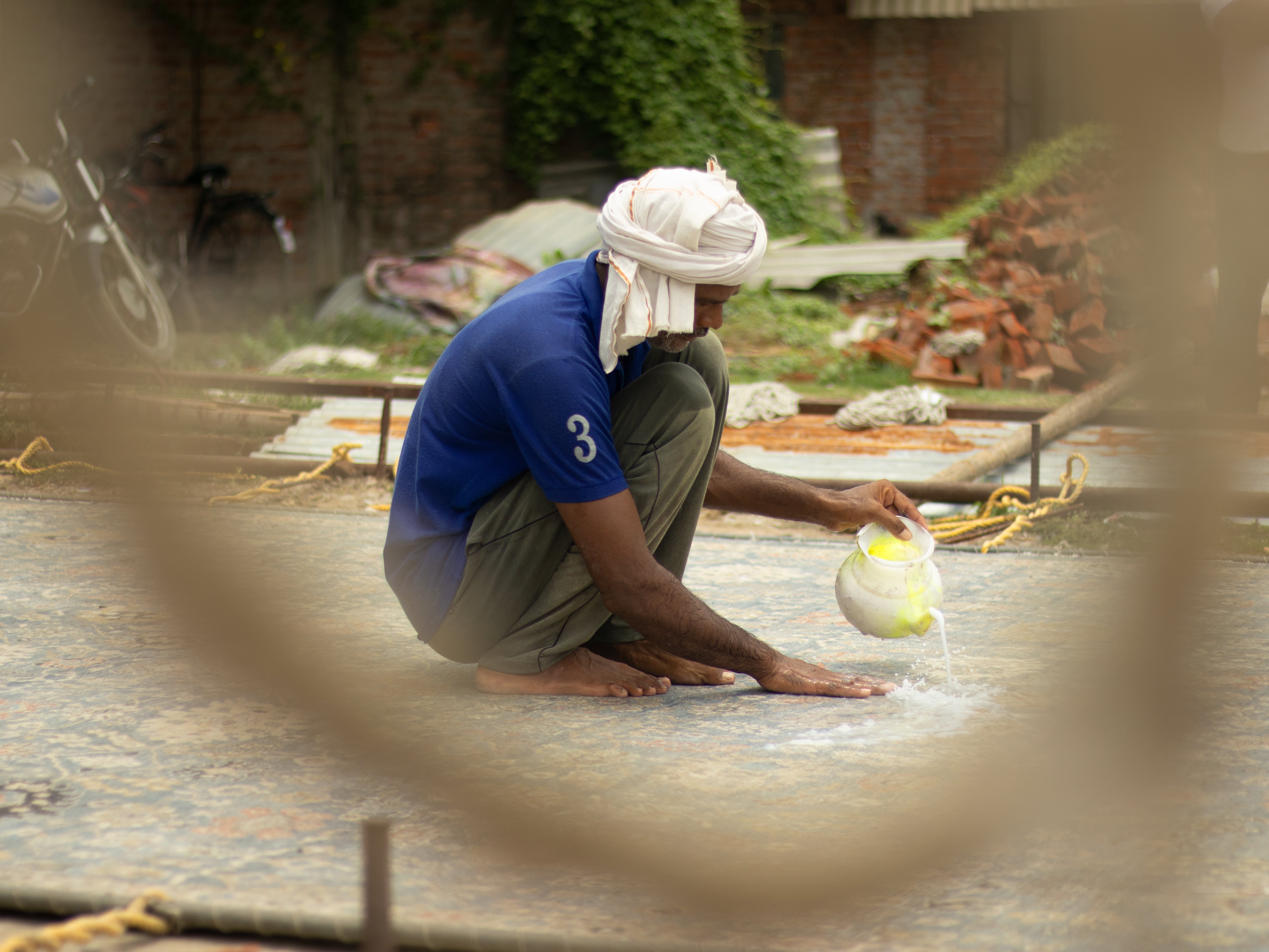 Craftsman washing a luxury handmade carpet during the final finishing stage, ensuring premium quality and durability.