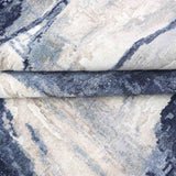 Luxury abstract rug with blue and beige tones, showcasing intricate woven texture and elegant design.
