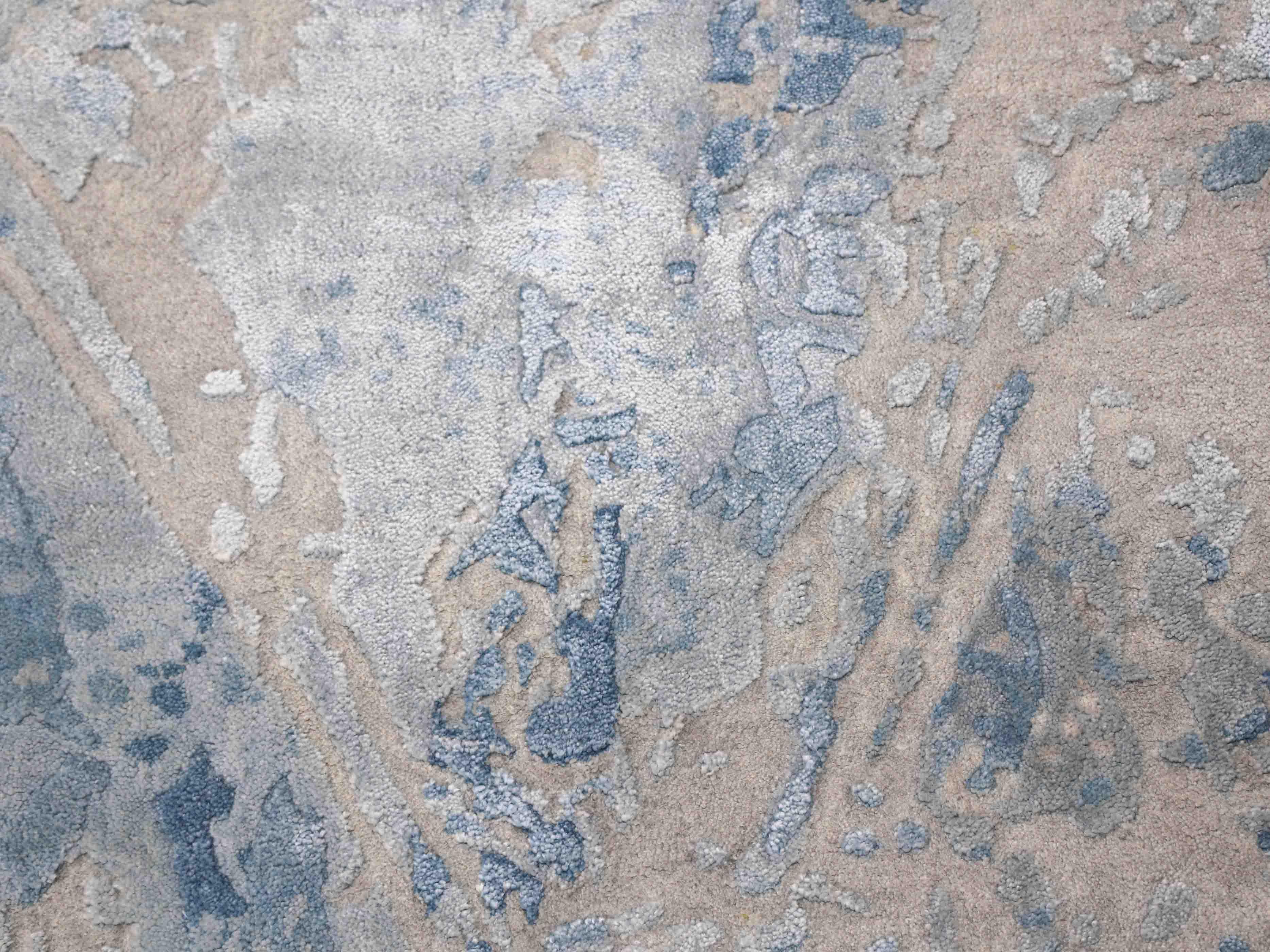 Luxury handcrafted rug with abstract blue and beige patterns, adding elegance to home decor