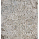 A vintage-style rug with a faded floral and geometric pattern in muted beige, pink, and taupe tones, creating an antique and elegant appearance.
