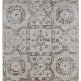 Elegant vintage-style rug with intricate geometric and floral patterns in muted beige and brown tones, conveying a rustic and timeless ambiance.