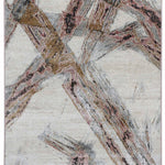 Abstract patterned rug featuring intersecting lines in earthy tones of brown, pink, and gray on a light beige background. The design appears dynamic and textured.