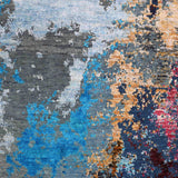 Abstract luxury rug with vibrant blue, pink, and gold accents on a gray textured background
